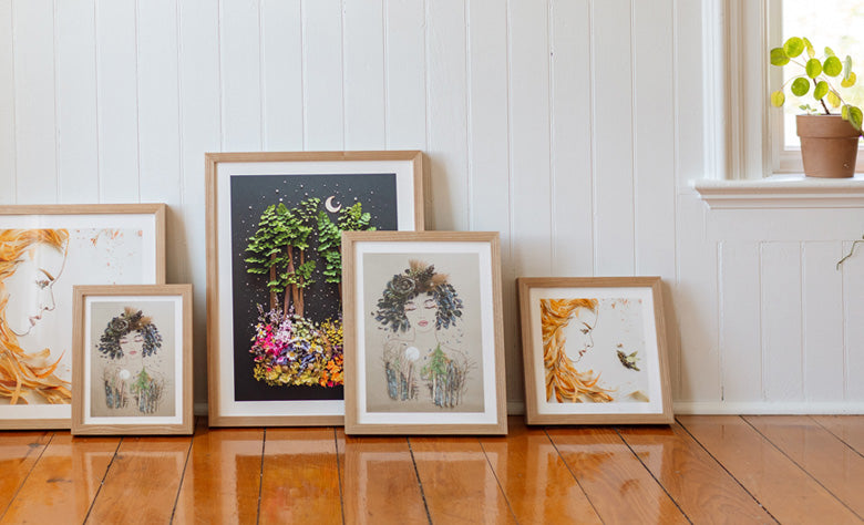 Frames lined up on floor leaning against wall